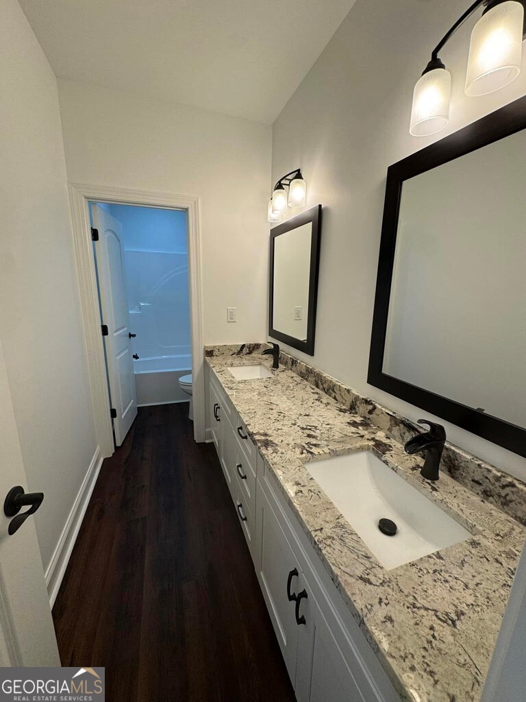 230 Woodland Heights Road Dublin, GA 31021 - Photo 22 of 30 a bathroom with a granite countertop sink and a mirror