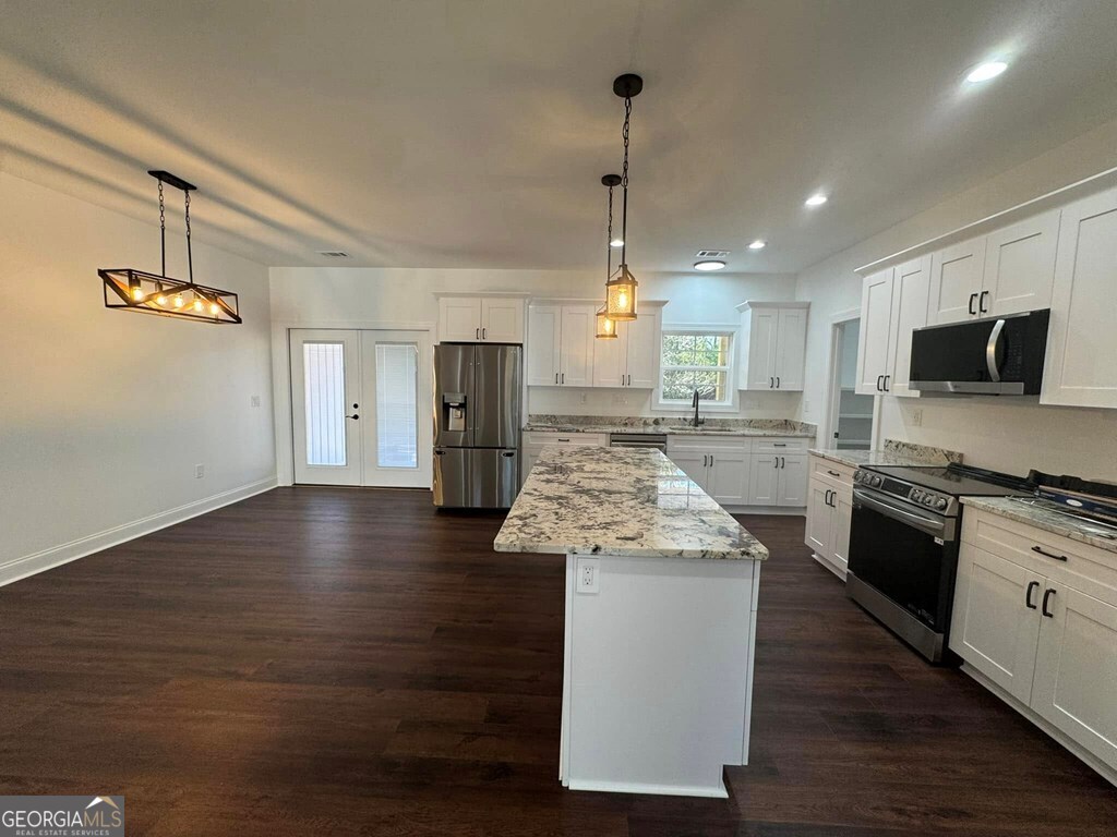 230 Woodland Heights Road Dublin, GA 31021 - Photo 6 of 30 a kitchen with stainless steel appliances granite countertop a sink stove and wooden floor