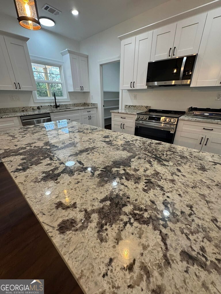 230 Woodland Heights Road Dublin, GA 31021 - Photo 7 of 30 a kitchen with kitchen island a stove a sink and a microwave