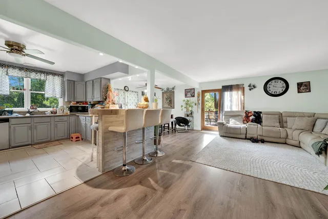 a kitchen with granite countertop a refrigerator a sink a stove top oven and cabinetry