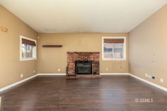 613 South Silver Ridge Street Ridgecrest, CA 93555 - Photo 13 of 26 an empty room with fireplace and windows