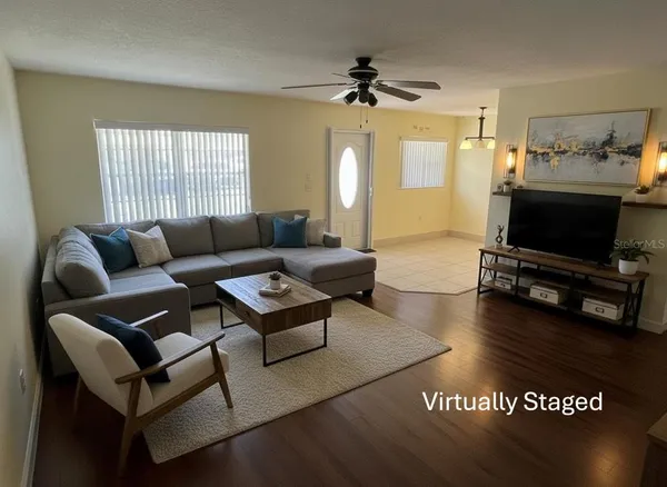 a living room with furniture a flat screen tv and a window