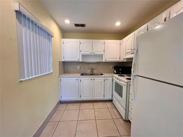 a kitchen with granite countertop white cabinets and white appliances