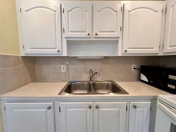 a kitchen with white cabinets and a sink