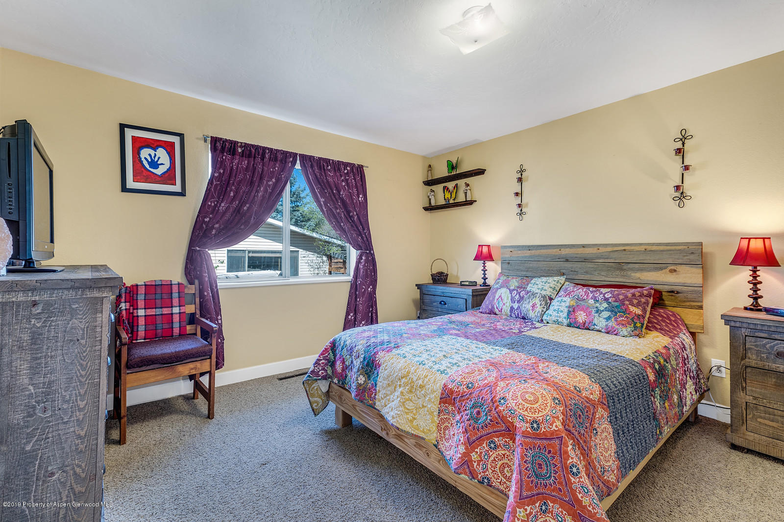 740 East 5th Street Rifle, CO 81650 - Photo 14 of 21 a bedroom with a bed a dresser and chair