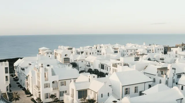 a view of a white building in front of a house