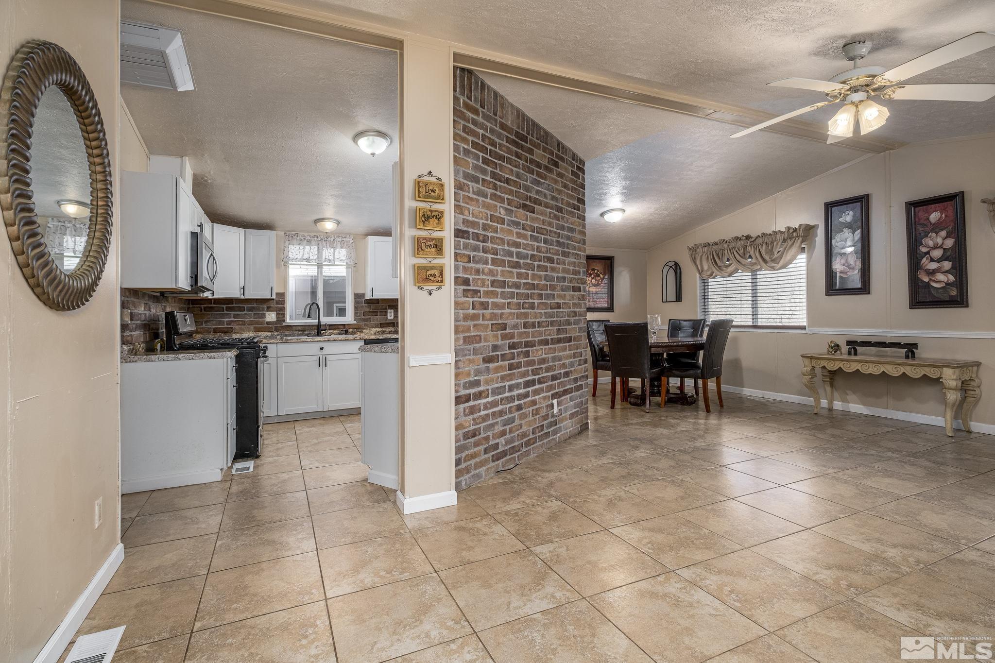 1670 Rockchuck Road Reno, NV 89506 - Photo 2 of 31 a kitchen with stainless steel appliances kitchen island granite countertop a stove a sink a dining table and chairs