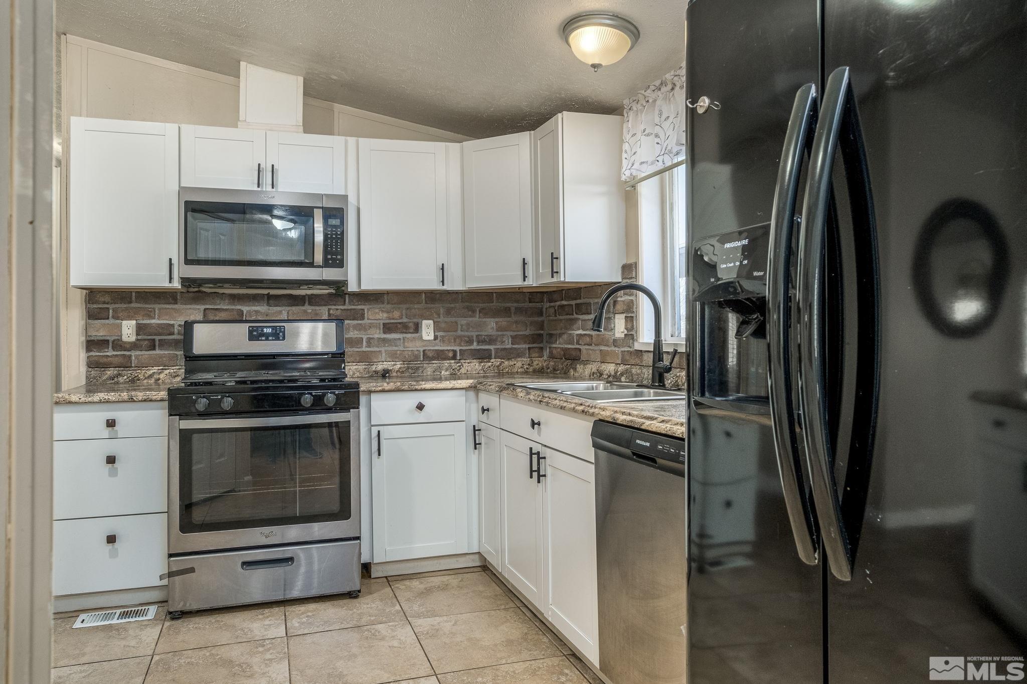 1670 Rockchuck Road Reno, NV 89506 - Photo 7 of 31 a kitchen with granite countertop a stove sink and refrigerator