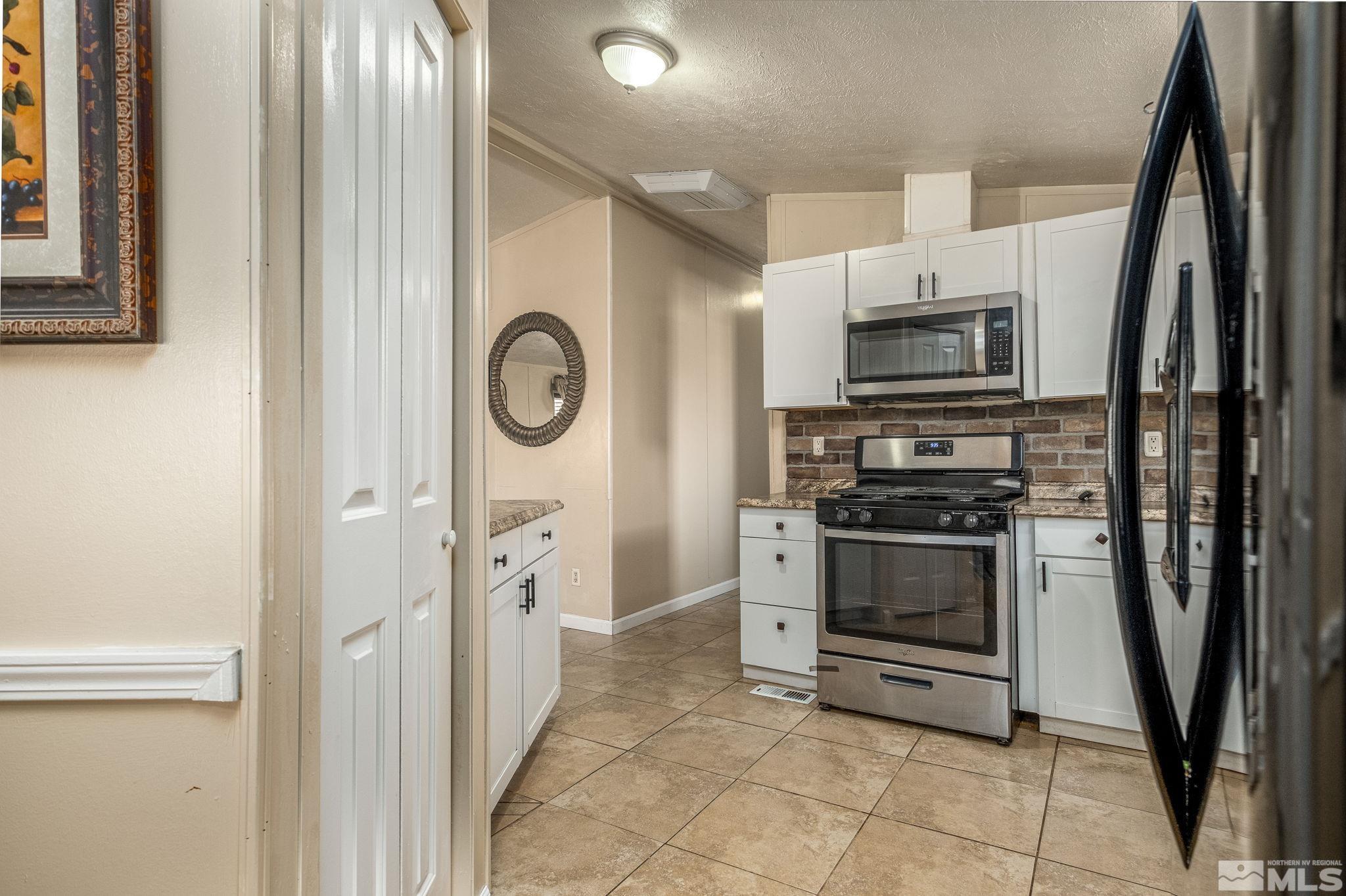 1670 Rockchuck Road Reno, NV 89506 - Photo 8 of 31 a kitchen with stainless steel appliances a stove a microwave and a refrigerator