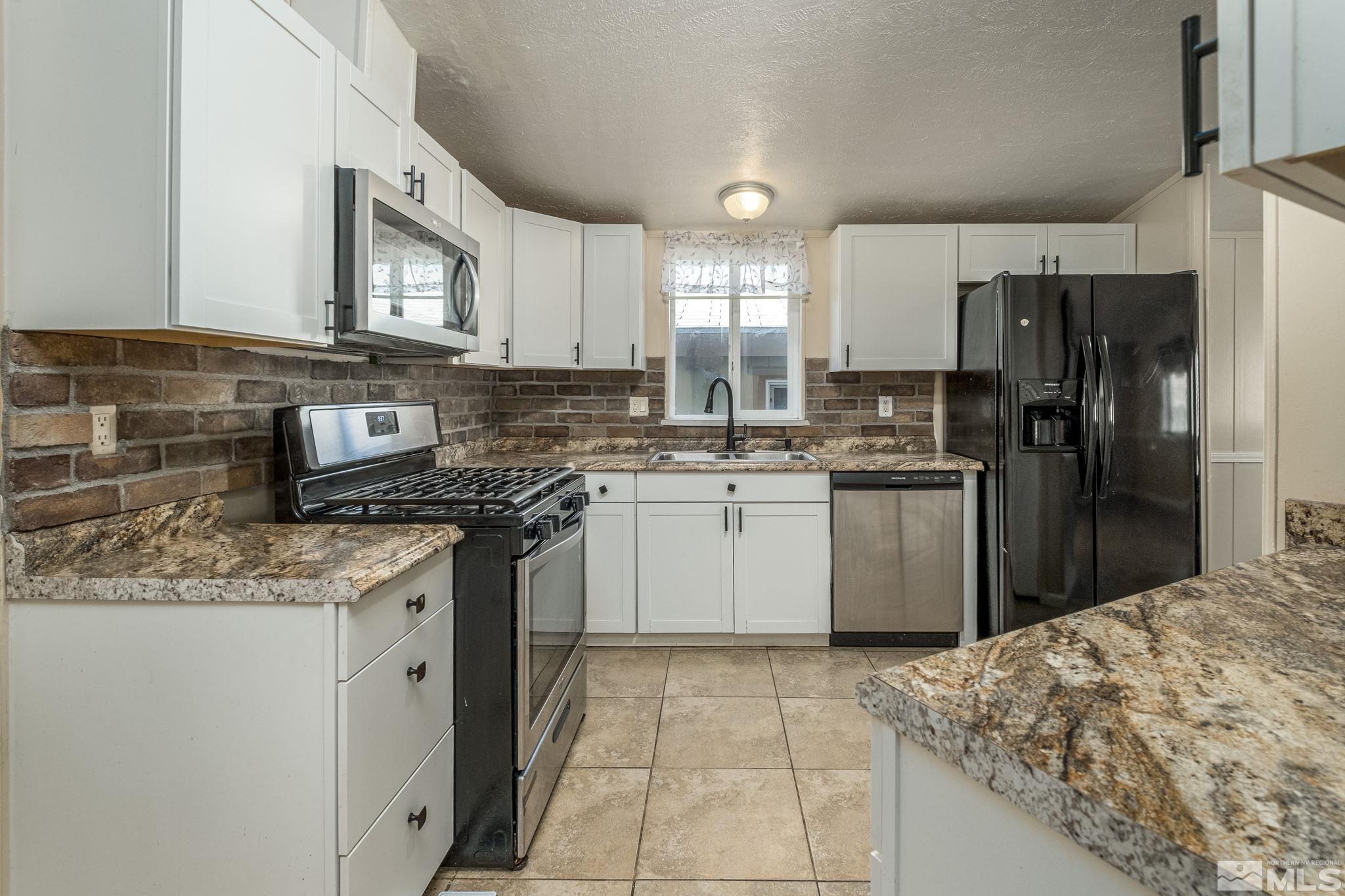 1670 Rockchuck Road Reno, NV 89506 - Photo 9 of 31 a kitchen with stainless steel appliances granite countertop a sink stove refrigerator and cabinets