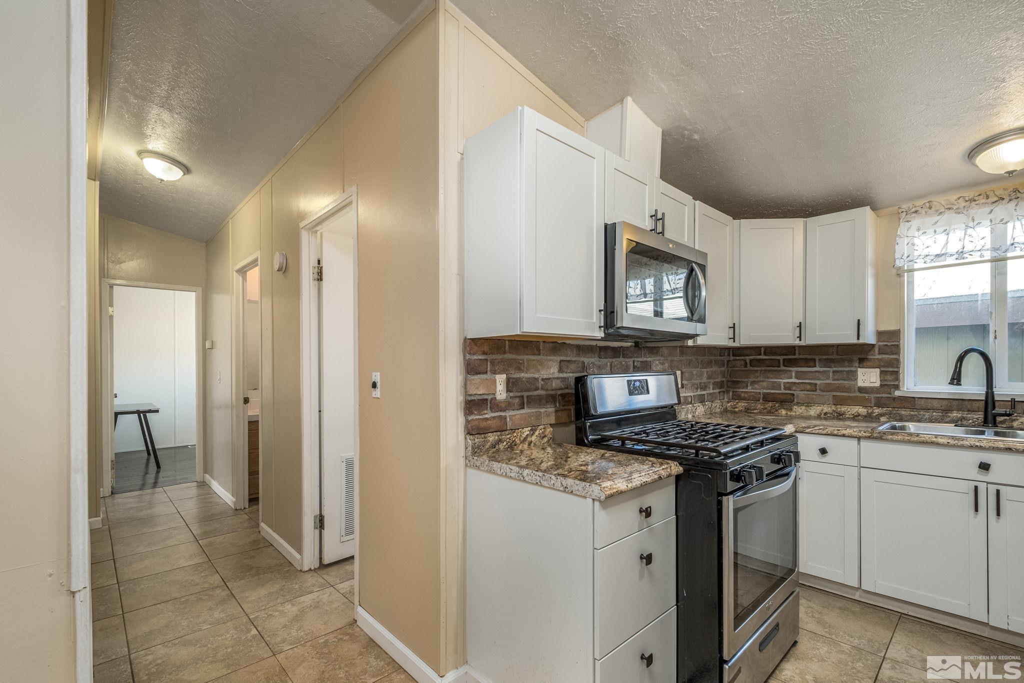 1670 Rockchuck Road Reno, NV 89506 - Photo 10 of 31 a kitchen with stainless steel appliances granite countertop a sink stove and refrigerator