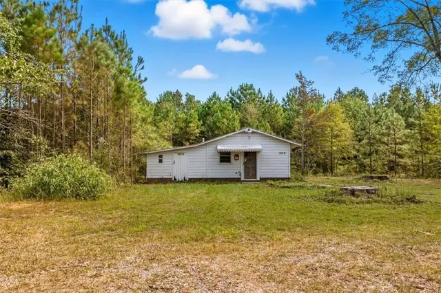 a yellow house with a yard in front of it