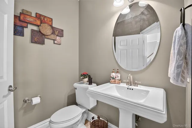 a bathroom with a sink mirror and toilet
