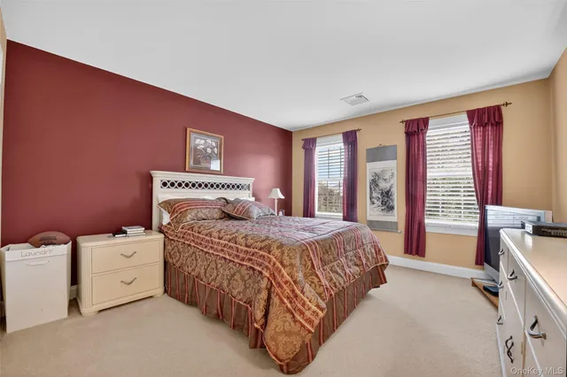 a bedroom with a bed and a dresser next to a window