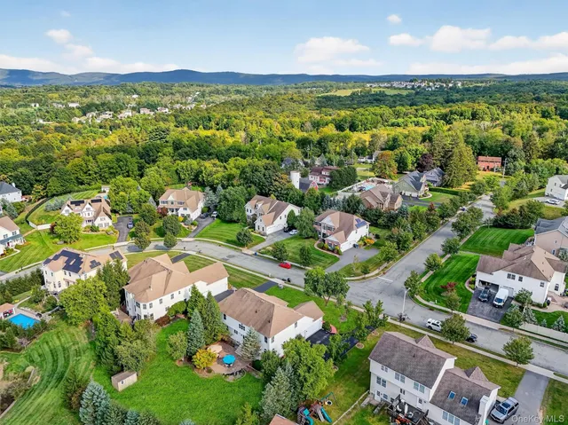 an aerial view of residential houses with outdoor space and trees
