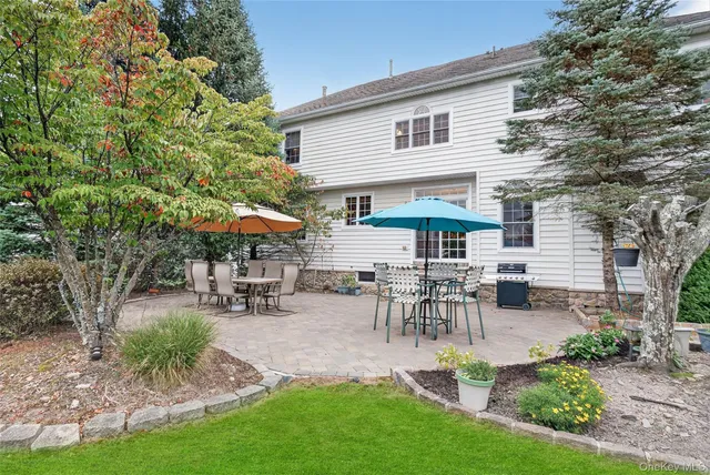 a view of a patio with table and chairs under an umbrella