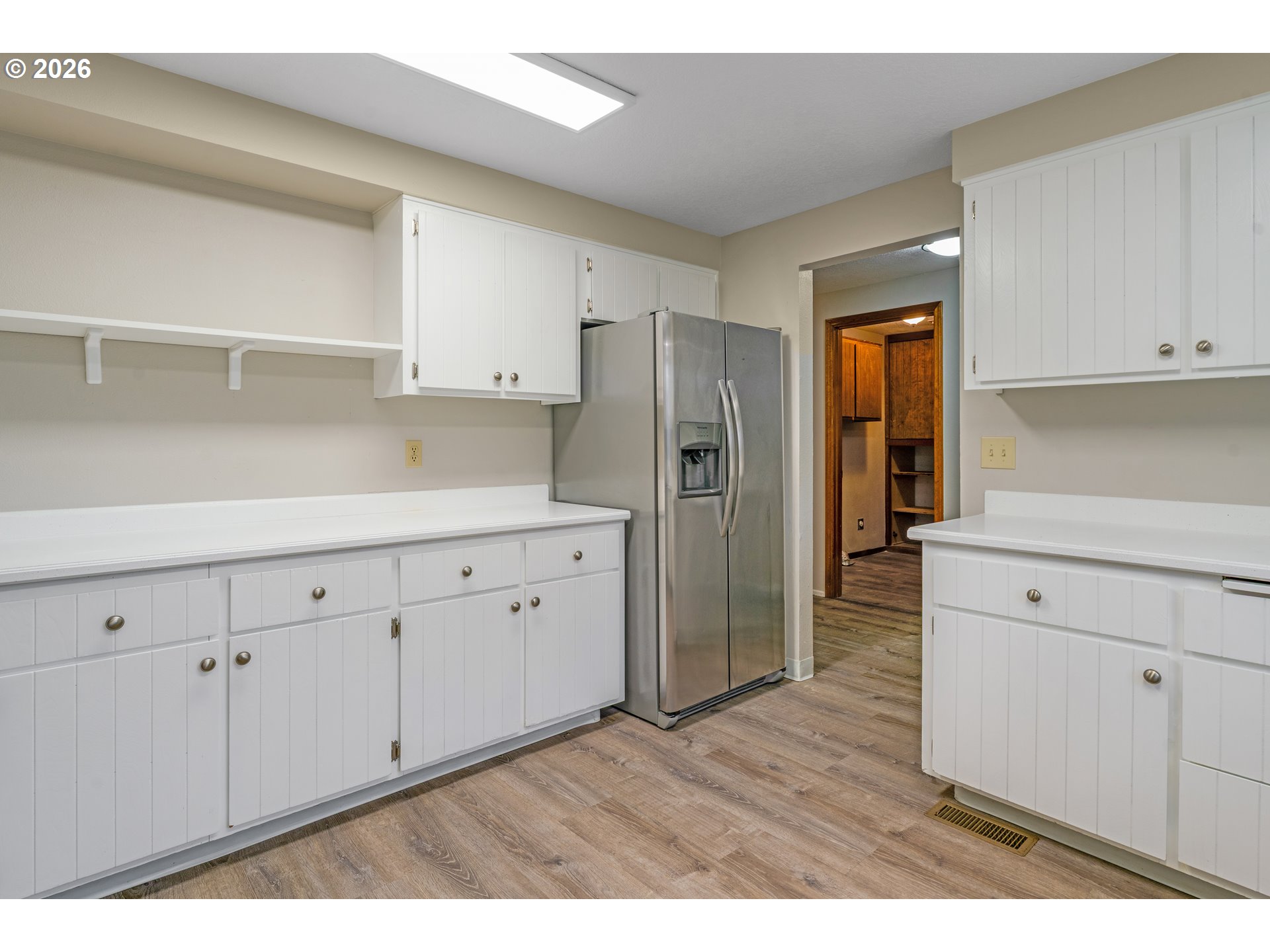 17839 Southwest Meadowbrook Way Beaverton, OR 97078 - Photo 14 of 45 a kitchen with white cabinets and wooden floor