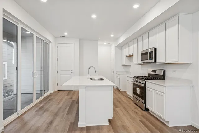a kitchen with stainless steel appliances granite countertop a sink stove oven and refrigerator