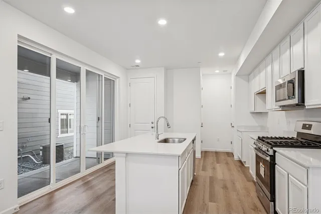 a kitchen with counter top space a sink stainless steel appliances and cabinets