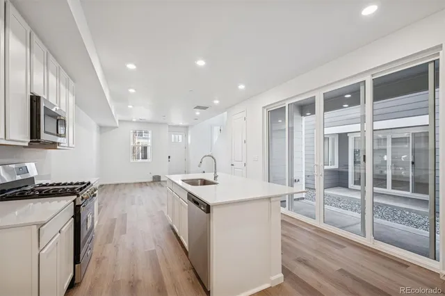a kitchen with granite countertop sink stove and refrigerator