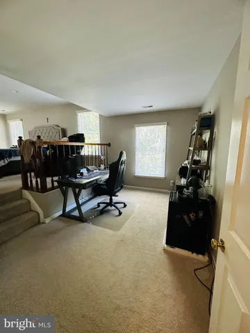 a view of a livingroom with workspace and a window
