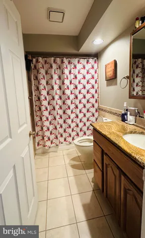 a bedroom with a bed a table and a dresser next to a window