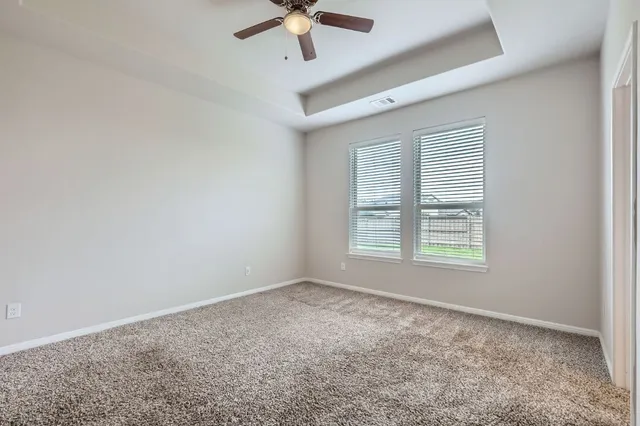 an empty room with a window and a fan