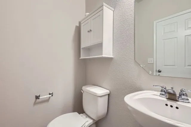 a bathroom with a toilet sink and mirror