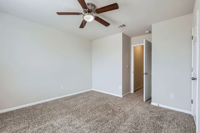 an empty room with closet and fan