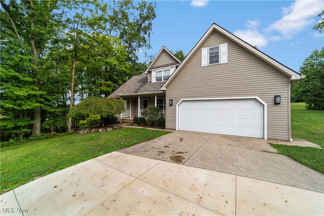30825 Cannon Road Solon, OH 44139 - Photo 2 of 49 Traditional home featuring a porch, driveway, a front yard, and a garage