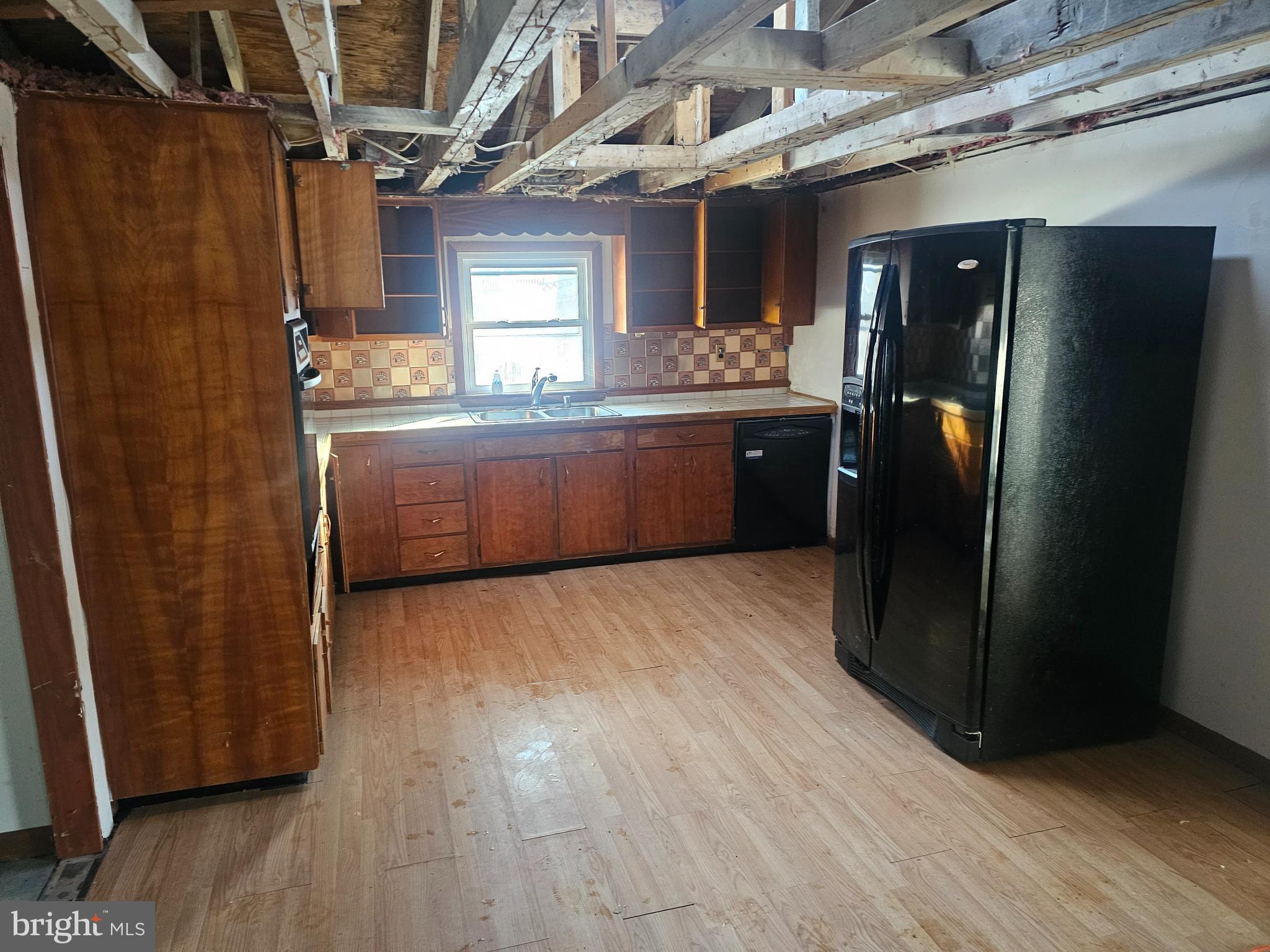 1915 Arundel Road Pasadena, MD 21122 - Photo 6 of 16 a kitchen with stainless steel appliances granite countertop a refrigerator and wooden cabinets