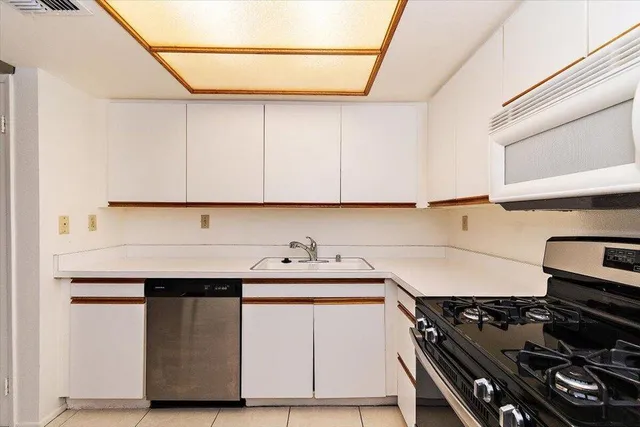 a kitchen with a refrigerator stove and white cabinets