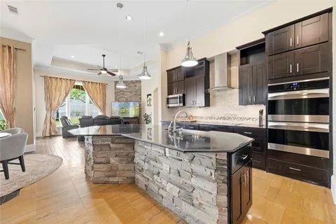 a large kitchen with stainless steel appliances a stove a faucet and a refrigerator