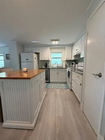 a large kitchen with stainless steel appliances granite countertop a stove a sink dishwasher and a refrigerator