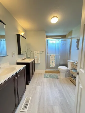 a spacious bathroom with a sink a toilet and a large mirror