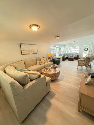 a living room with couches and kitchen view