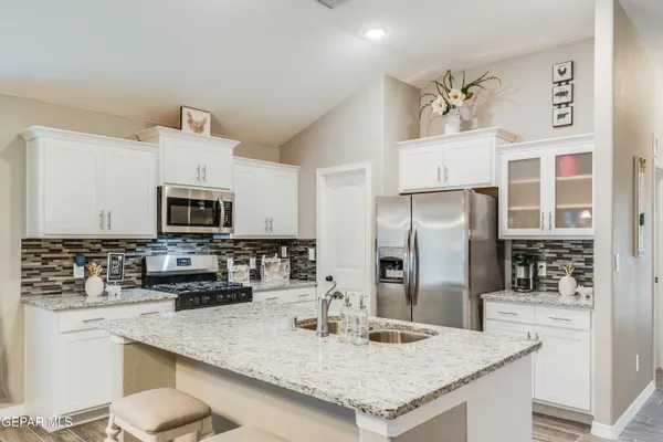 a kitchen with stainless steel appliances granite countertop a sink stove and refrigerator