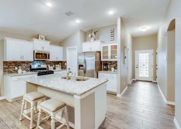 a kitchen with a counter top space a sink appliances and cabinets