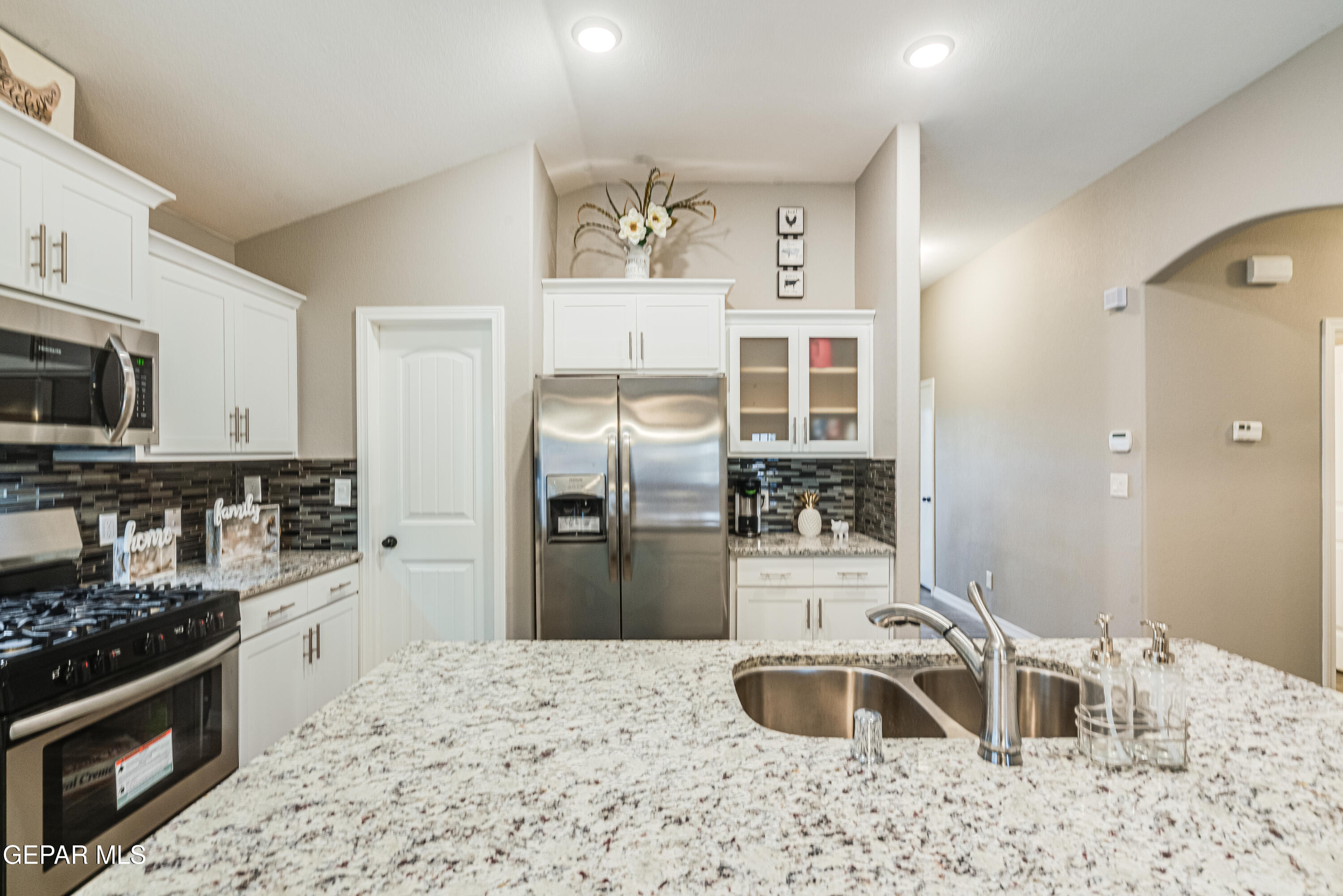 512 Caddo Lane Clint, TX 79836 - Photo 17 of 38 a kitchen with stainless steel appliances kitchen island granite countertop a refrigerator stove and sink