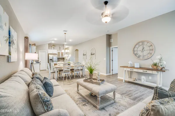 a living room with furniture a chandelier and a clock