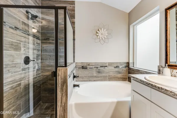 a bathroom with a granite countertop sink and a mirror