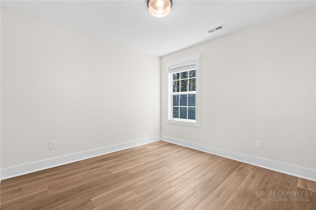 228 Stratford Lane Boone, NC 28607 - Photo 22 of 33 a view of an empty room with wooden floor and a window