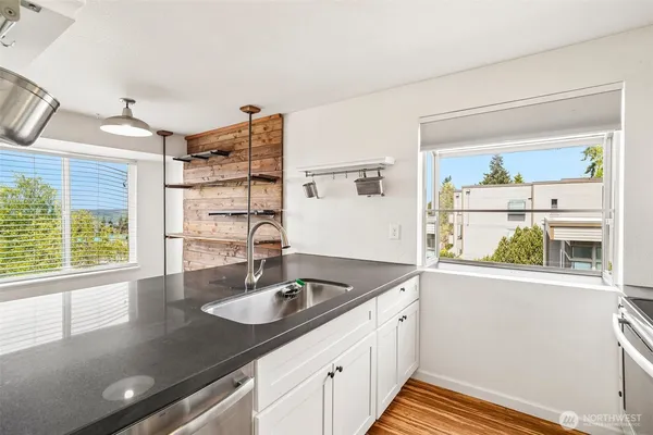a kitchen with stainless steel appliances granite countertop a sink and a window