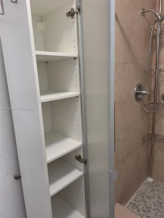 an empty room with wooden floor and cabinet