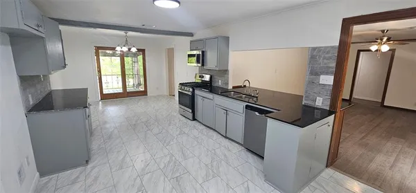 a kitchen with granite countertop a stove and wooden floor