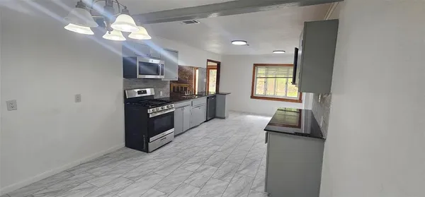 a large kitchen with cabinets and stainless steel appliances