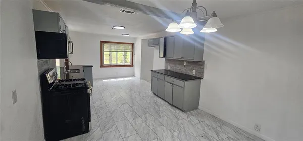 a kitchen with a refrigerator and a stove top oven