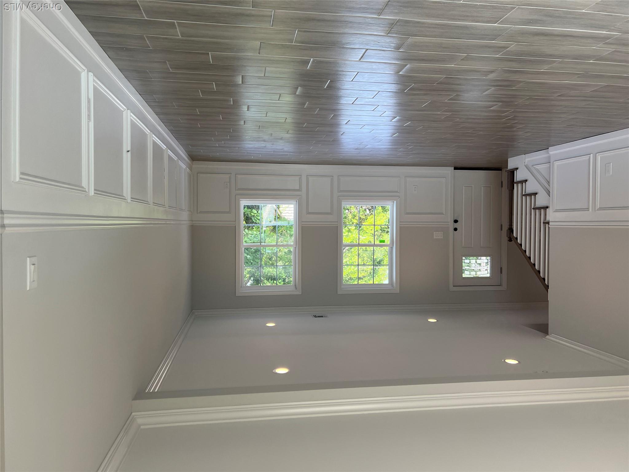 35 Babylon Road Mastic Beach, NY 11951 - Photo 4 of 19 an empty room with wooden floor and windows