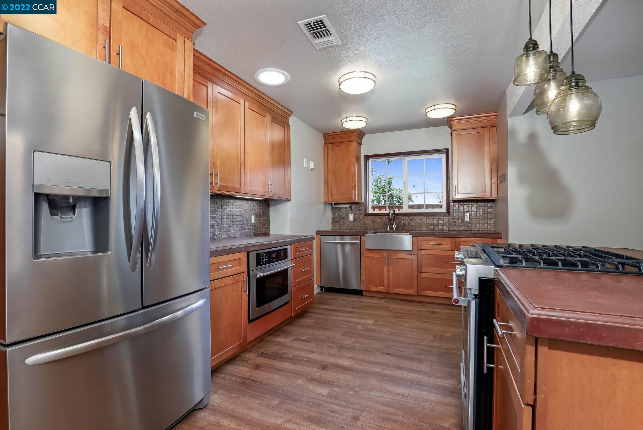 2144 Dena Drive Concord, CA 94519 - Photo 5 of 27 a kitchen with a refrigerator sink and wooden cabinets