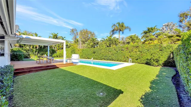 a view of swimming pool with lawn chairs and plants